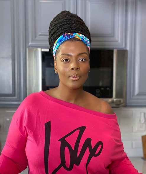 A woman in a pink shirt and blue headband.